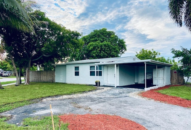 ranch-style home featuring a carport and a front lawn