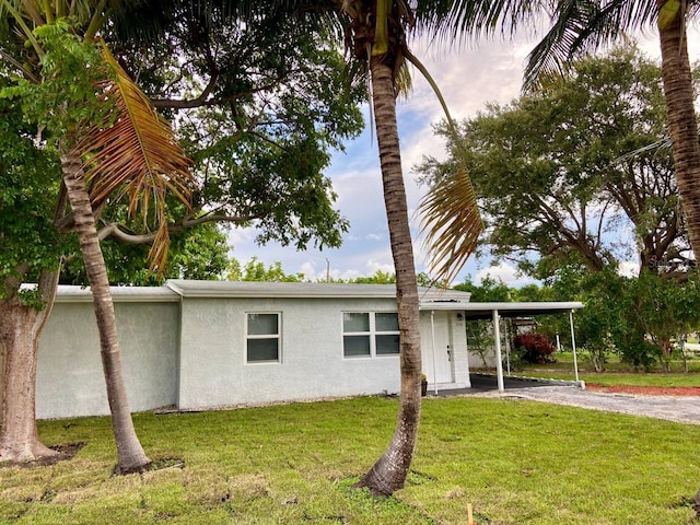 exterior space featuring a carport and a lawn