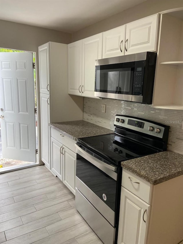 kitchen featuring backsplash, stainless steel appliances, and white cabinets