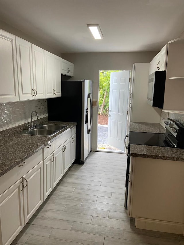 kitchen with white cabinets, sink, tasteful backsplash, appliances with stainless steel finishes, and light wood-type flooring