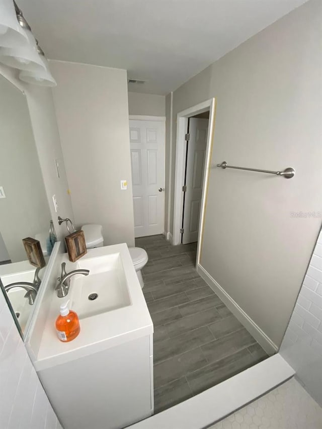 bathroom featuring hardwood / wood-style flooring, vanity, and toilet