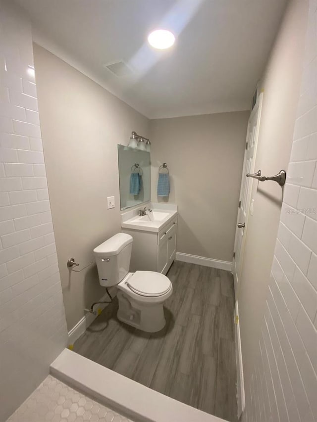 bathroom featuring wood-type flooring, vanity, and toilet