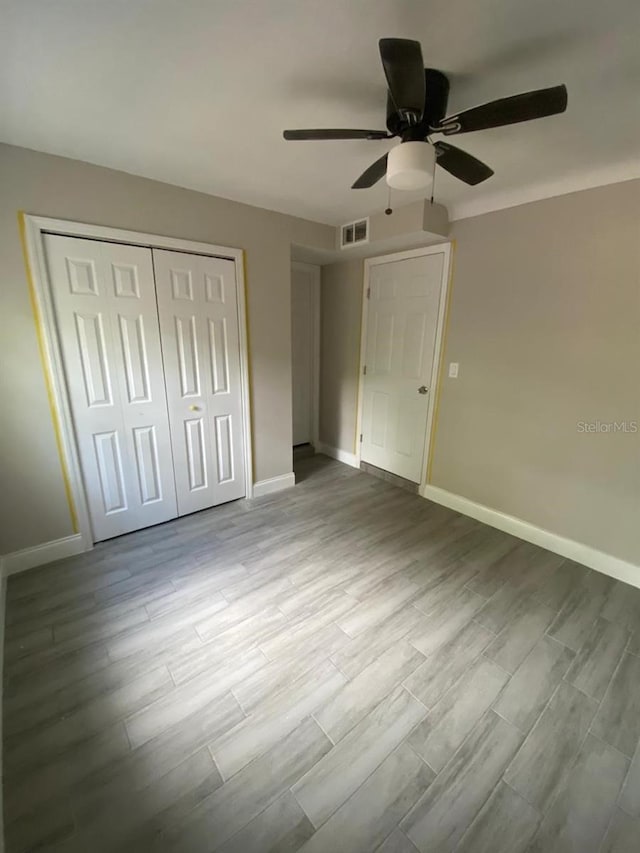 unfurnished bedroom with ceiling fan, a closet, and light hardwood / wood-style flooring