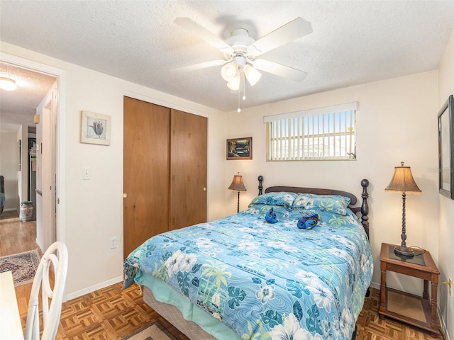 bedroom featuring parquet floors, a textured ceiling, a closet, and ceiling fan