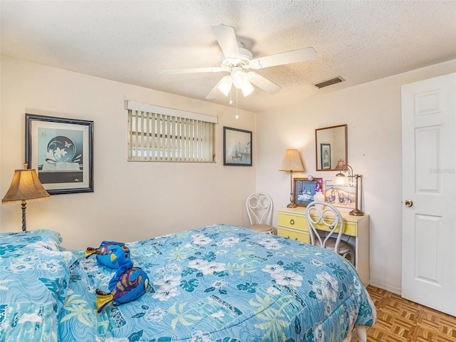 bedroom with parquet flooring, a textured ceiling, and ceiling fan