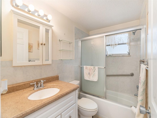 full bathroom with a textured ceiling, shower / bath combination with glass door, toilet, tile walls, and vanity