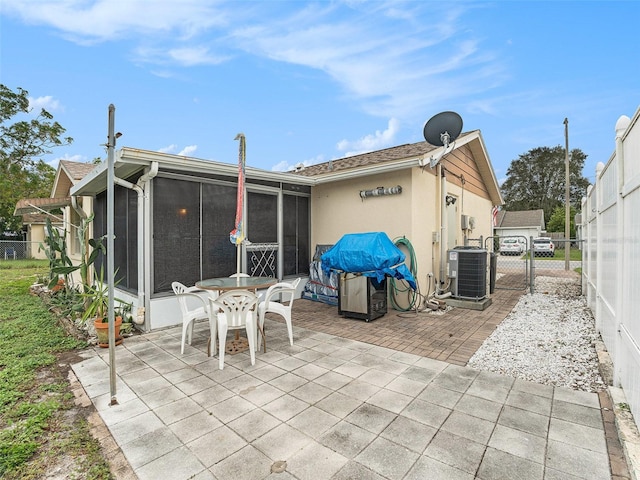 rear view of property featuring a sunroom, central AC, and a patio area