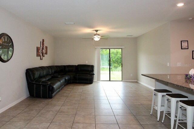 tiled living room featuring ceiling fan