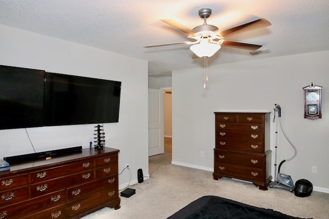 carpeted bedroom featuring ceiling fan and a textured ceiling