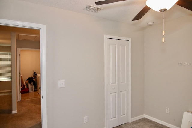 unfurnished bedroom with carpet, ceiling fan, and a closet