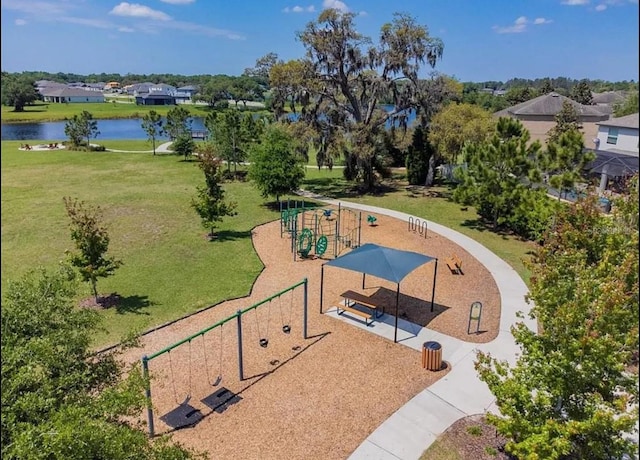 view of home's community with a playground, a yard, and a water view