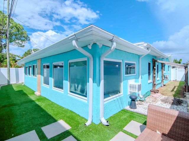 view of side of property with a fenced backyard, a yard, and stucco siding