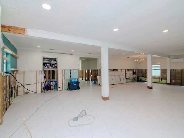 basement featuring recessed lighting, a wall mounted air conditioner, and an inviting chandelier