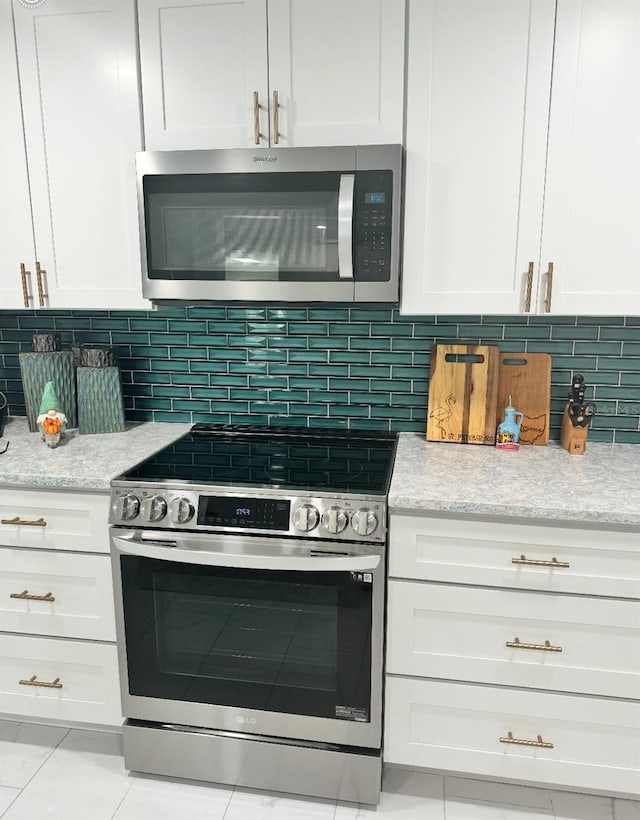 kitchen featuring white cabinets, backsplash, and stainless steel appliances