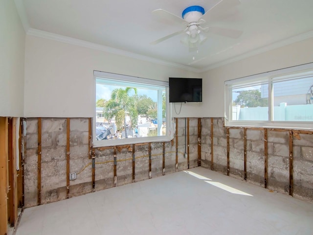 unfurnished room with plenty of natural light, a ceiling fan, and ornamental molding