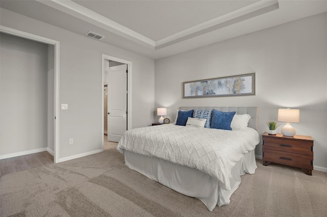 bedroom with a raised ceiling and carpet floors