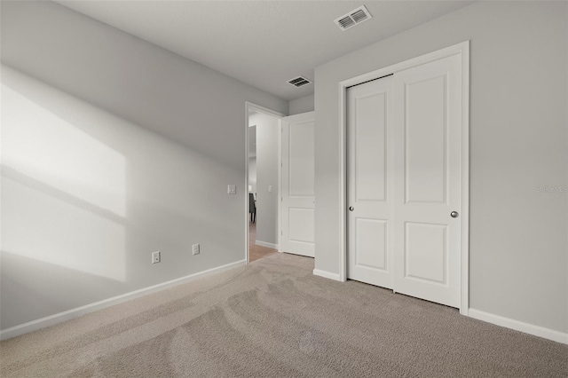 unfurnished bedroom featuring carpet floors and a closet