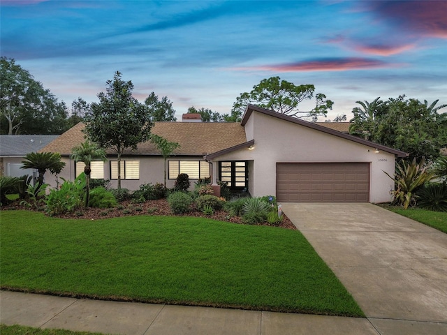 view of front of home featuring a garage and a lawn