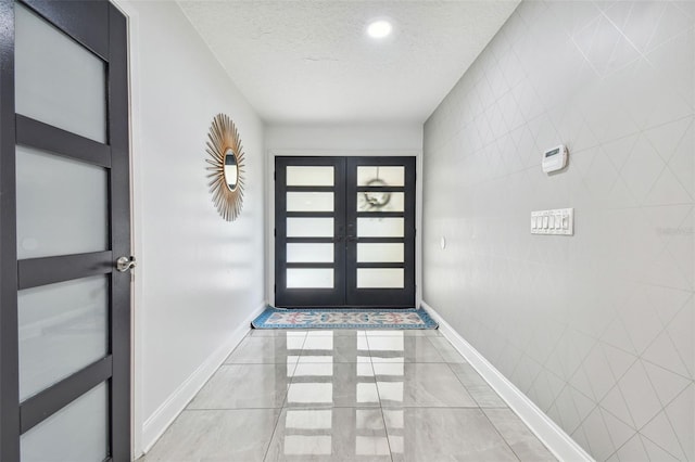 doorway with french doors and a textured ceiling