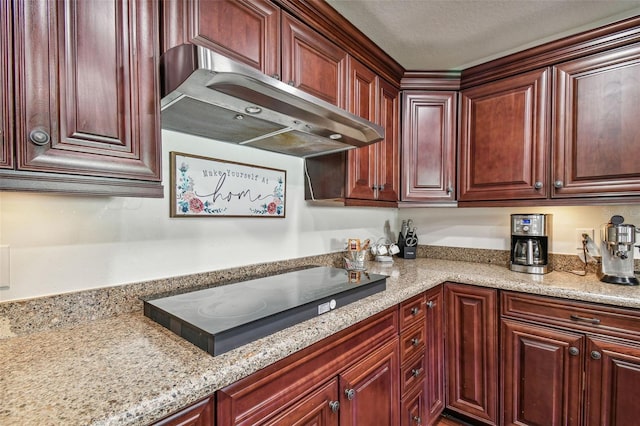 kitchen featuring light stone counters and black electric stovetop