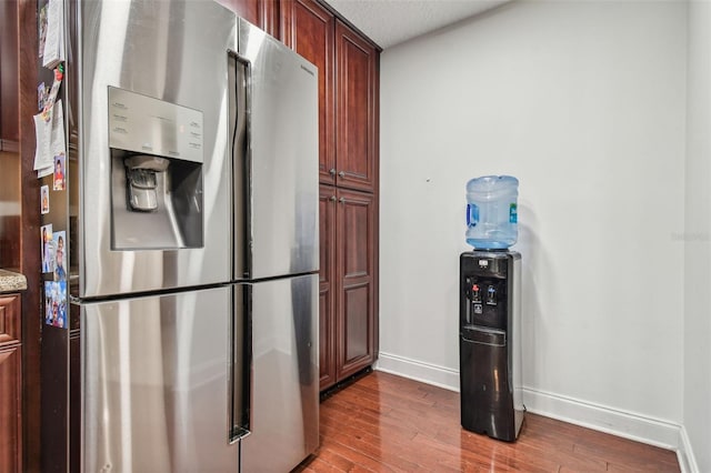 kitchen featuring a textured ceiling, stainless steel fridge, and wood-type flooring