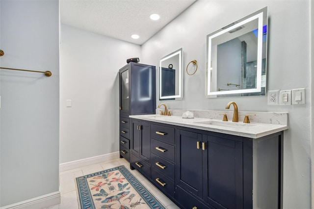 bathroom with tile patterned flooring, vanity, and a textured ceiling