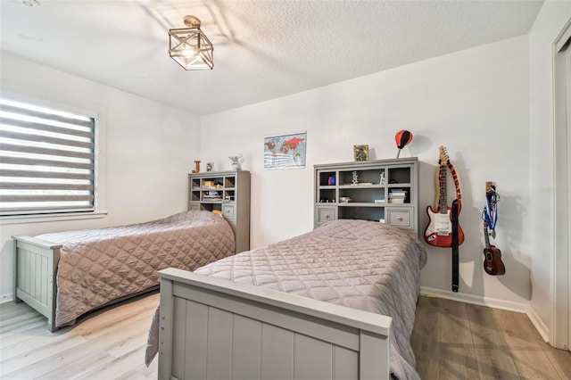 bedroom with light hardwood / wood-style floors and a textured ceiling