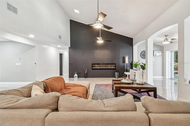 living room with ceiling fan, a fireplace, and high vaulted ceiling