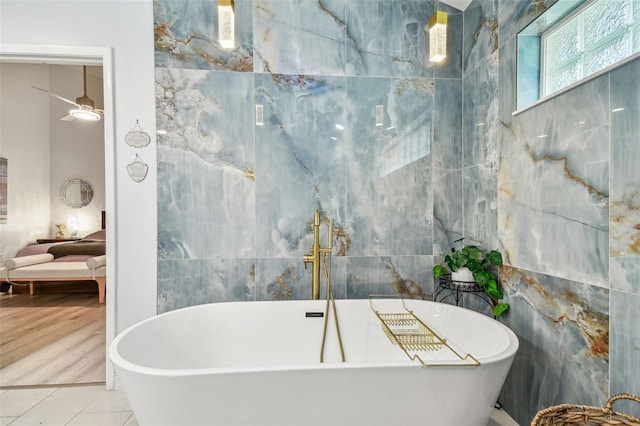 bathroom with tile patterned floors, tile walls, and a tub