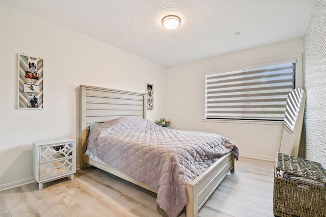 bedroom featuring light hardwood / wood-style flooring and a textured ceiling