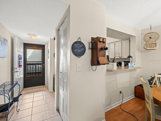 corridor featuring light hardwood / wood-style floors and a textured ceiling