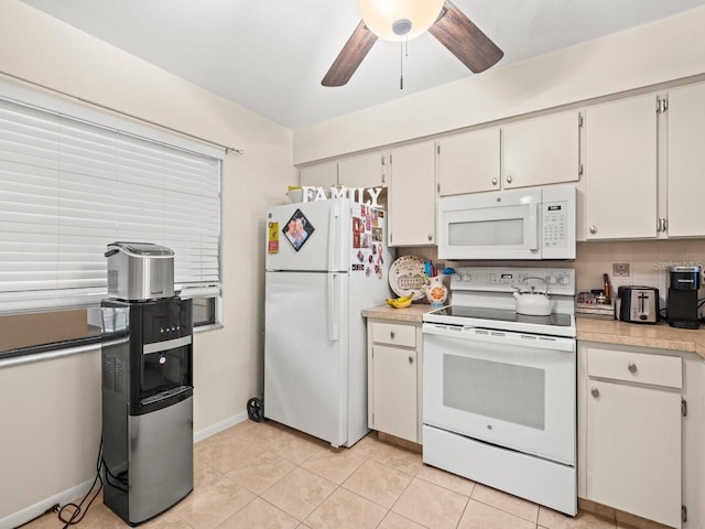 kitchen with white appliances, white cabinets, light tile patterned floors, and tasteful backsplash