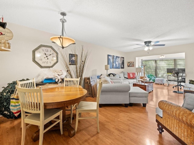 dining space featuring light hardwood / wood-style floors, a textured ceiling, and ceiling fan