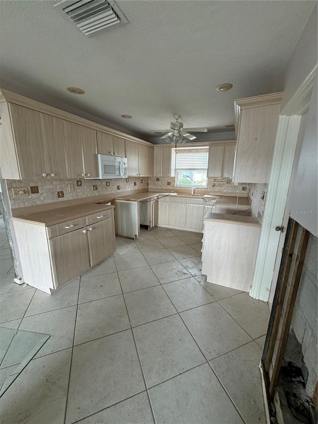 kitchen featuring light brown cabinets, light tile patterned floors, ceiling fan, and backsplash