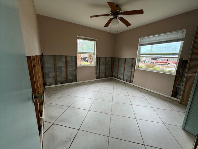 tiled empty room featuring ceiling fan