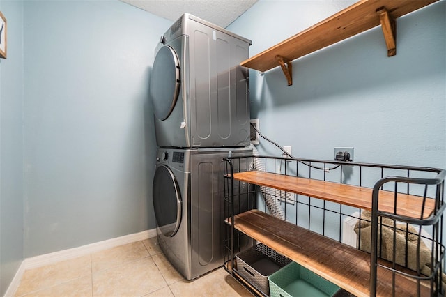 clothes washing area featuring stacked washing maching and dryer and light tile patterned floors