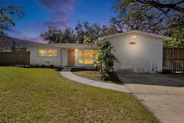 single story home featuring a lawn