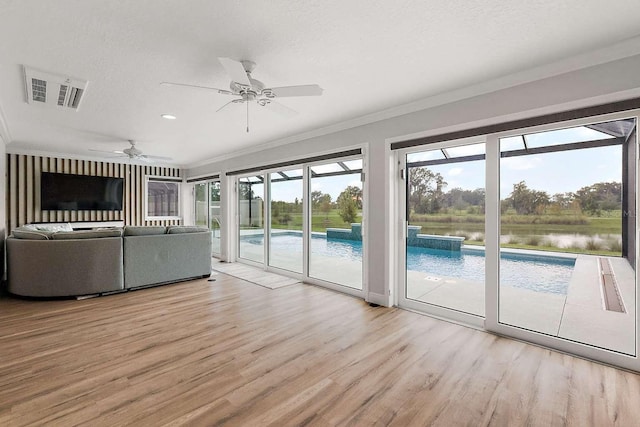 unfurnished living room featuring a water view, ceiling fan, light hardwood / wood-style floors, crown molding, and a textured ceiling