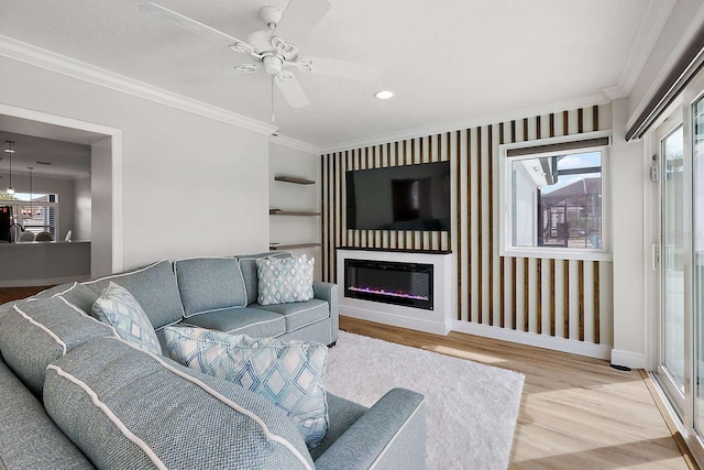 living room with crown molding, ceiling fan, and wood-type flooring