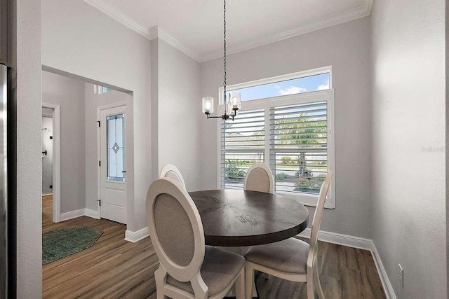 dining area with ornamental molding, a chandelier, and dark hardwood / wood-style flooring