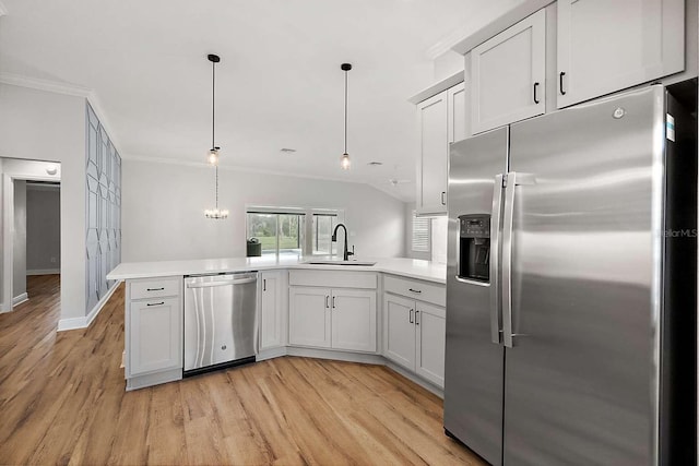 kitchen with kitchen peninsula, pendant lighting, light hardwood / wood-style floors, and stainless steel appliances