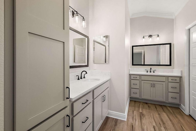 bathroom featuring hardwood / wood-style floors, lofted ceiling, crown molding, and vanity