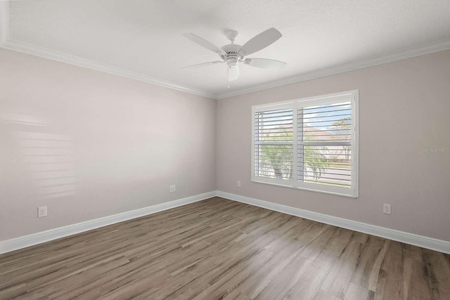 spare room with wood-type flooring, ornamental molding, and ceiling fan