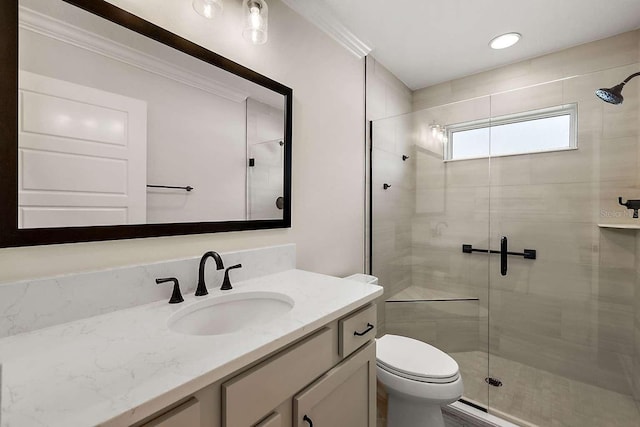 bathroom featuring walk in shower, ornamental molding, vanity, and toilet