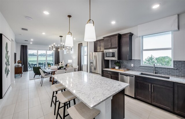 kitchen with plenty of natural light, decorative light fixtures, sink, and appliances with stainless steel finishes