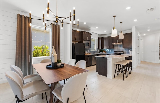 tiled dining room with sink and a chandelier