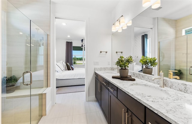 bathroom featuring tile patterned flooring, vanity, and a shower with door