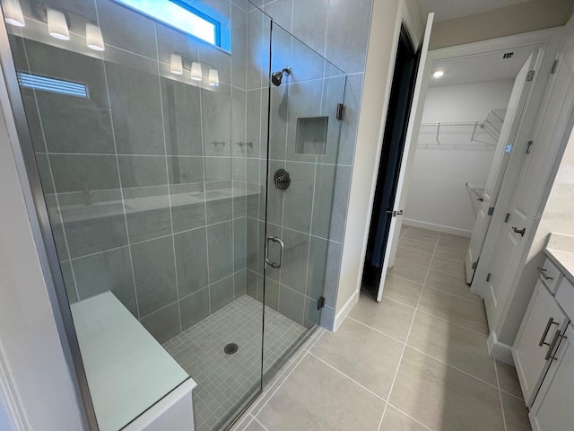 bathroom featuring tile patterned flooring, vanity, and an enclosed shower