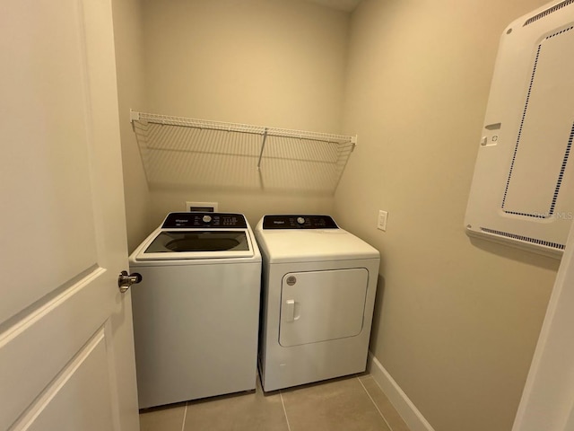 laundry area featuring washer and dryer and light tile patterned floors