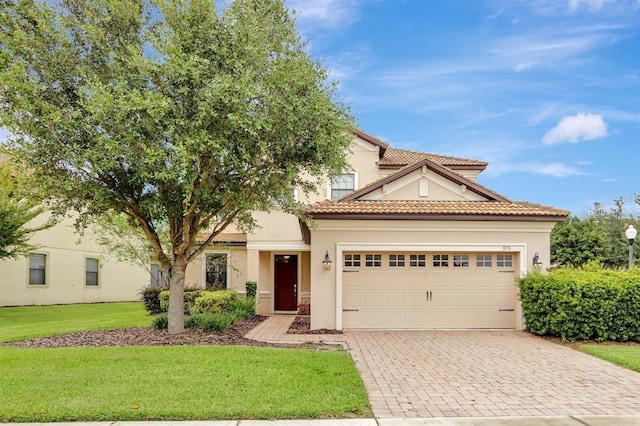 mediterranean / spanish home with a garage and a front yard